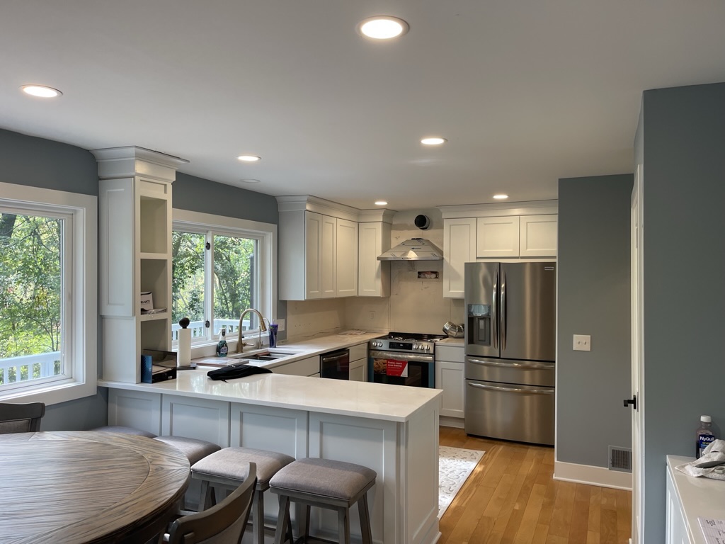 Renovated kitchen with white shaker cabinets, quartz counters, and open layout
