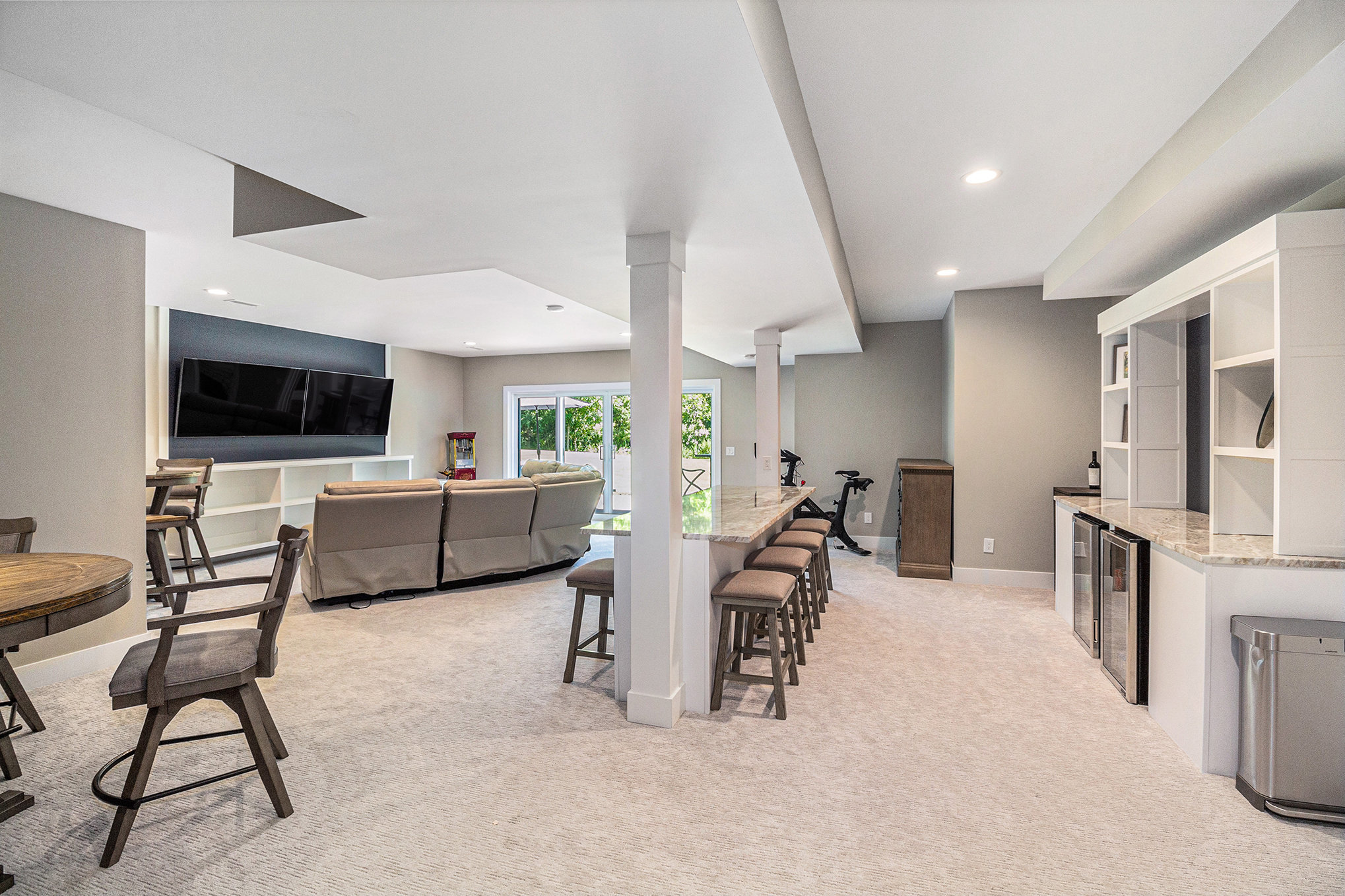 Finished basement with bar, theater seating, and walkout to patio